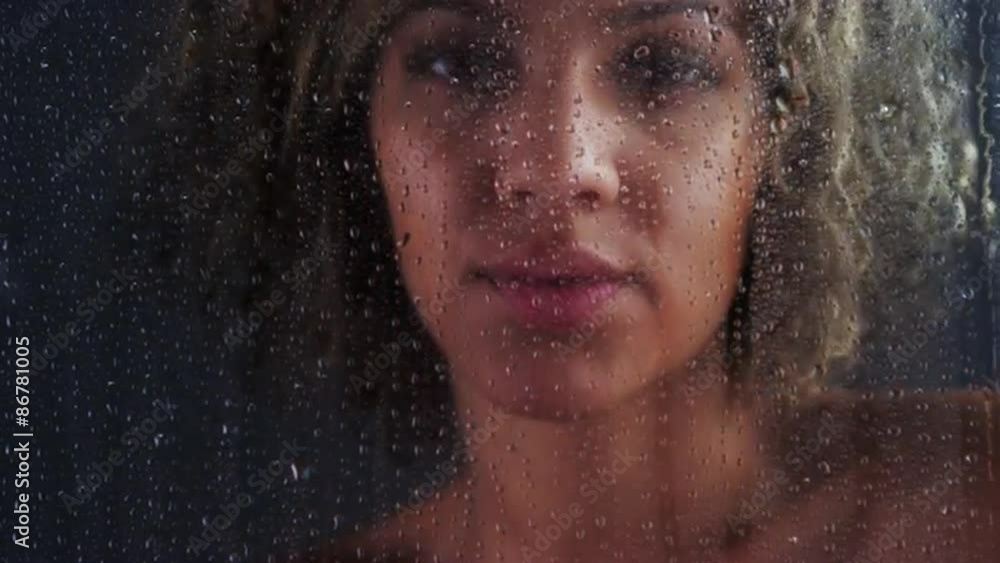 Nude black woman standing behind blurry glass Nude black woman standing behind blurry glass