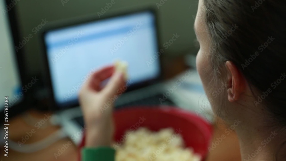 woman snacking on popcorn in a home office woman snacking on popcorn in a home office