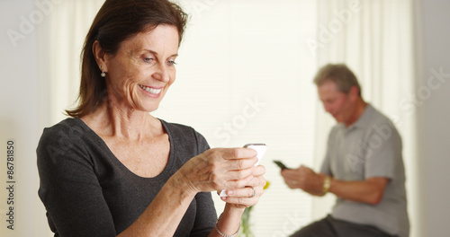 Senior woman happily using smartphone