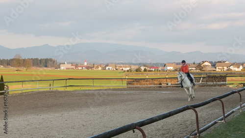 Girl galloping on white horse wide shot photo