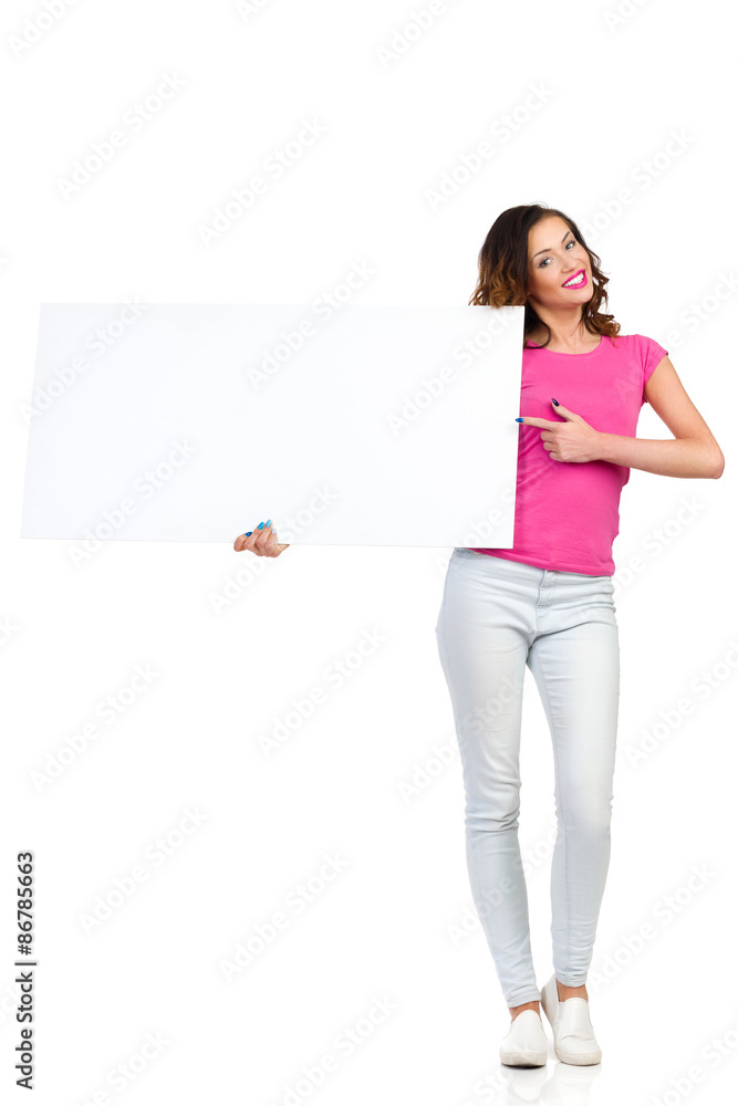 Smiling young woman holding white placard and pointing. Full length studio shot isolated on white Smiling young woman holding white placard and pointing. Full length studio shot isolated on white