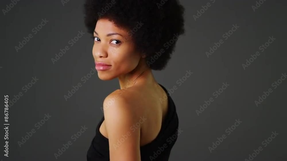 Rear view of African woman in black dress dancing slowly