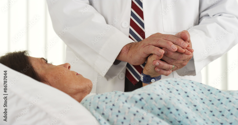 Doctor holding patient's hand and comforting her