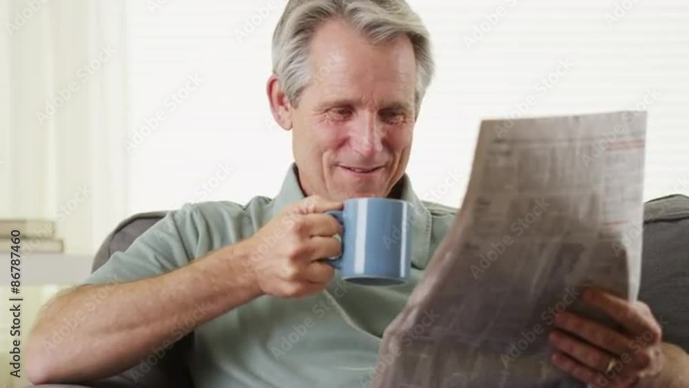 Happy senior smiling reading newspaper Happy senior smiling reading newspaper
