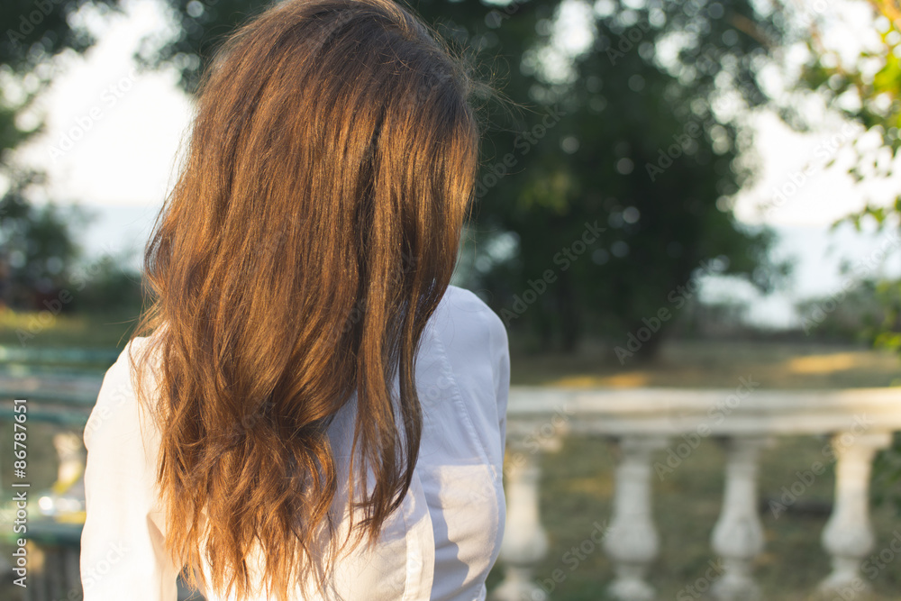 Young slender red-haired woman walking in the park sunny summer Young slender red-haired woman walking in the park sunny summer