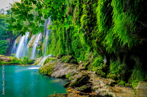 a beautiful waterfall in the forest on a river