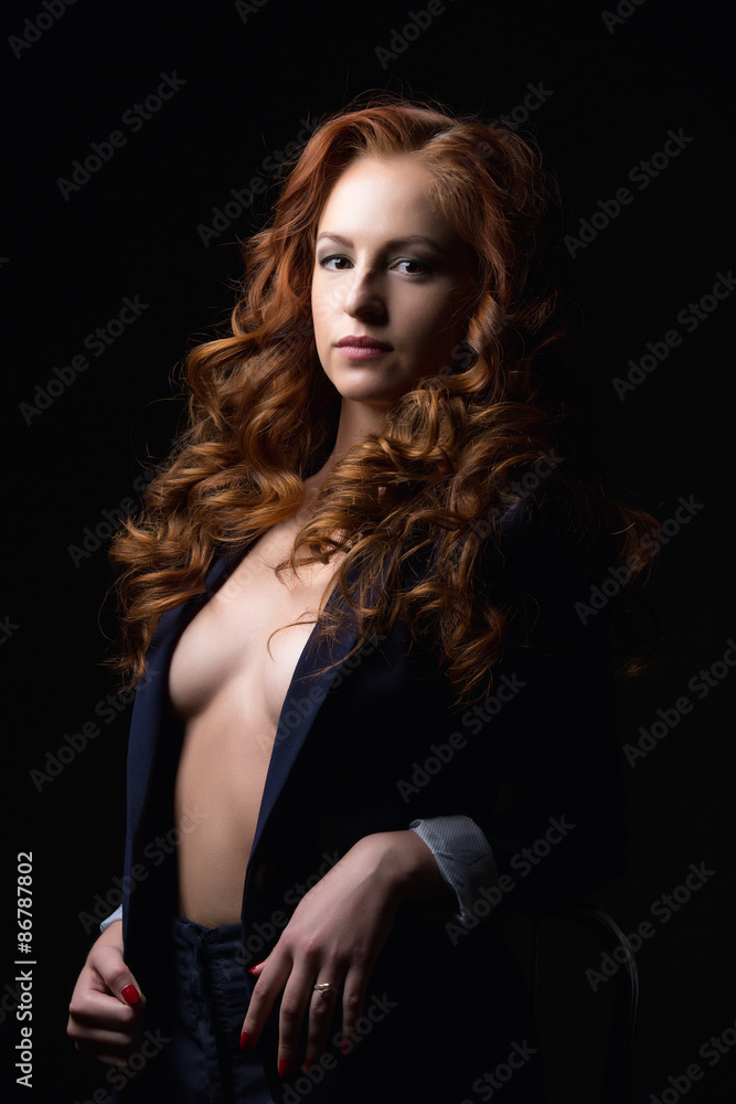 Red-haired model posing in jacket on naked body Red-haired model posing in jacket on naked body