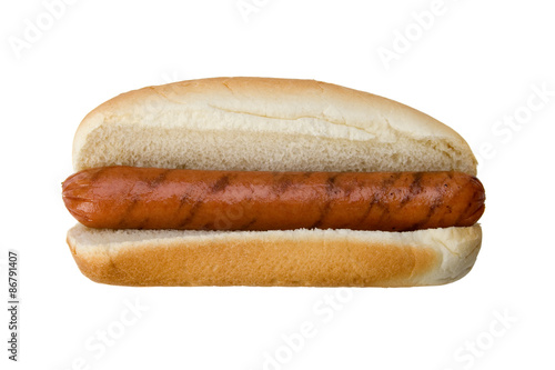Grilled Hot Dog in Bun – A grilled hot dog on plain white hot dog bun. No condiments. Isolated on white with clipping path.