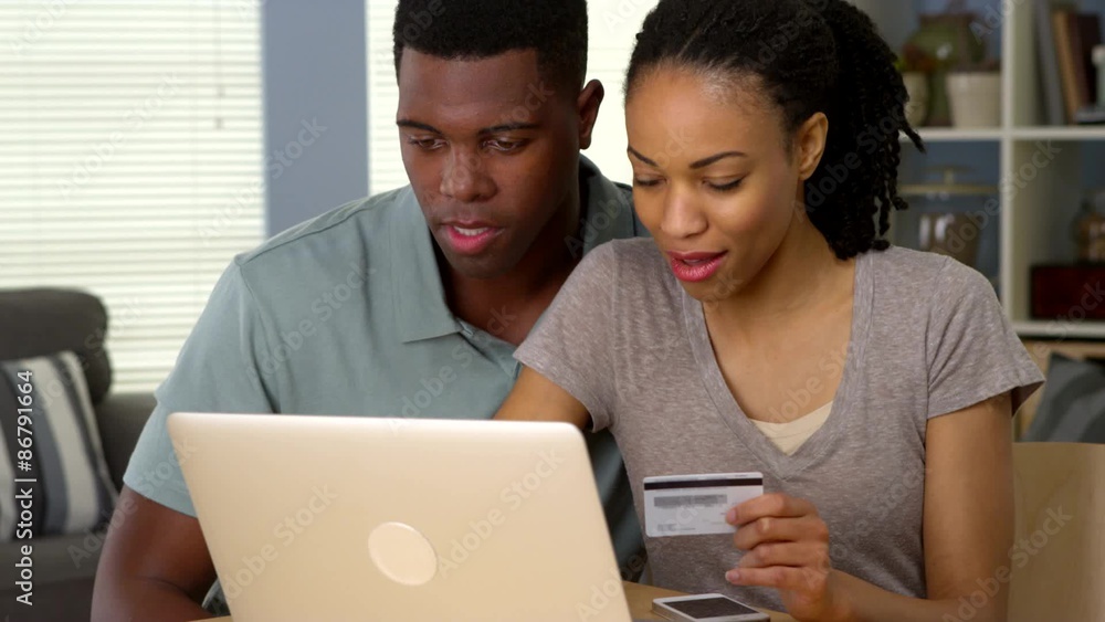 Happy African American man and woman making online purchase with credit card Happy African American man and woman making online purchase with credit card