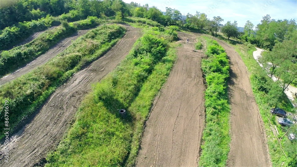 Racer jump on motocross dirt track aerial shot Racer jump on motocross dirt track aerial shot