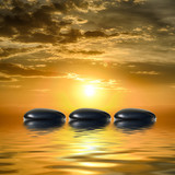 Zen spa concept background-Zen black massage stones reflected in water