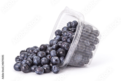 Box or punnet and spilled fresh ripe organic blueberries on a white background