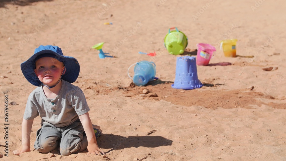 A little boy playing in sand with bucket and shovel A little boy playing in sand with bucket and shovel
