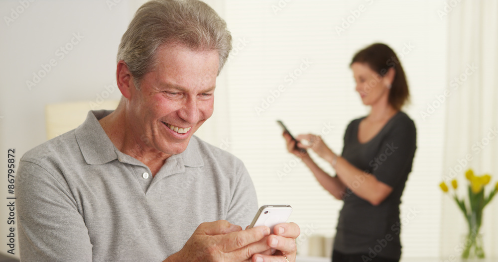 Cheerful senior man using smartphone Cheerful senior man using smartphone