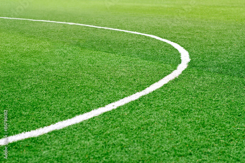 Green soccer field grass with white mark line, soft focus