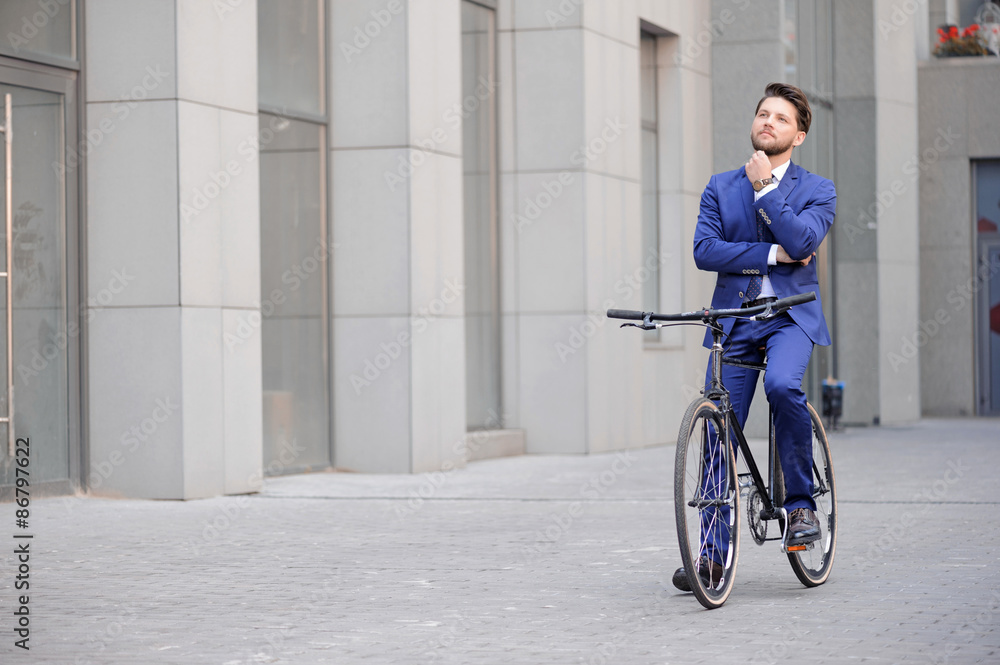 Handsome businessman riding his bicycle Handsome businessman riding his bicycle