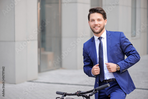 Handsome businessman riding his bicycle 