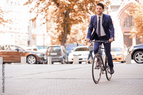 Handsome businessman riding his bicycle 