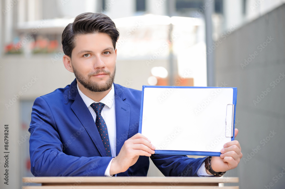 Pleasant man sitting at table with papers. Pleasant man sitting at table with papers.