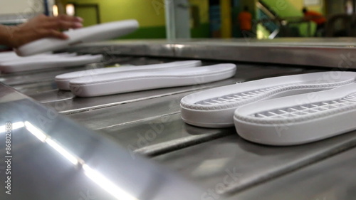 worker in footwear factory transfer shoe outsole on conveyor