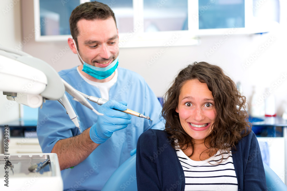Fototapeta premium Young attractive woman being cured by a dentist