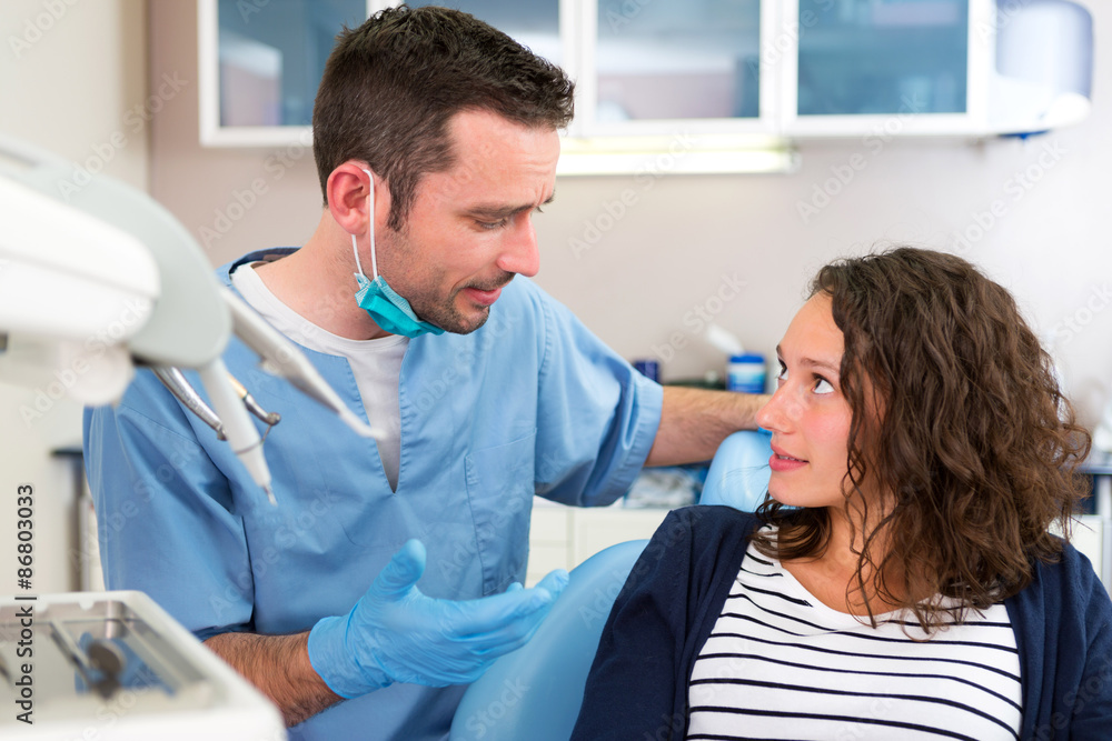 Young attractive dentist explaning his work to a patient Young attractive dentist explaning his work to a patient