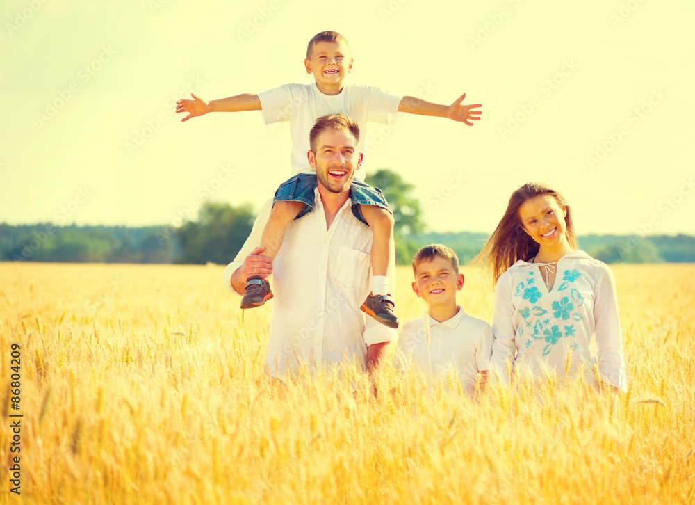 Naklejka premium Happy young family on wheat summer field