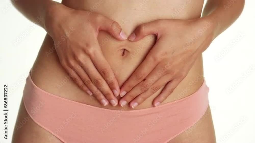 Asian woman in pink underwear holding stomach Asian woman in pink underwear holding stomach