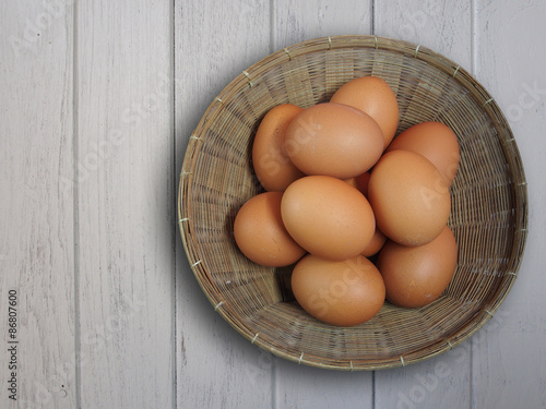 Fresh eggs in basket on wooden background