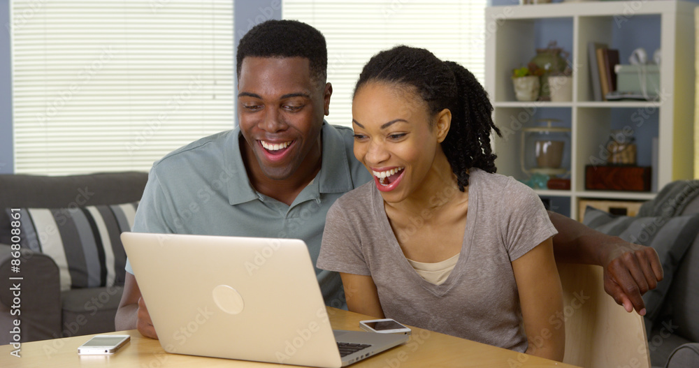 Young black couple watching funny video on laptop Young black couple watching funny video on laptop