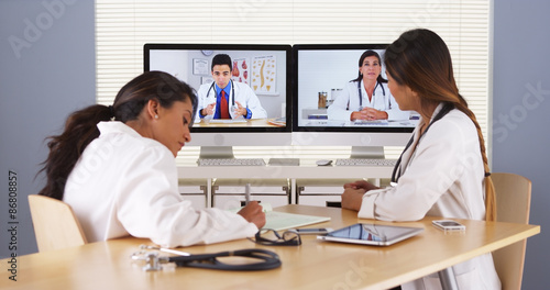 Professional team of multi-ethnic medical doctors having a video conference photo