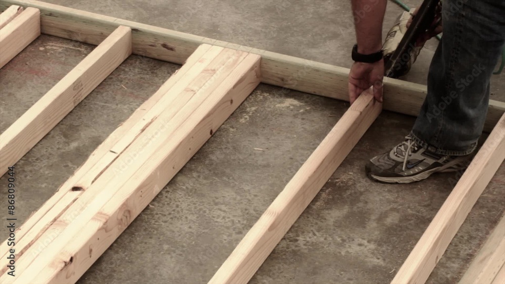 Builder constructing a wall with nail gun Builder constructing a wall with nail gun
