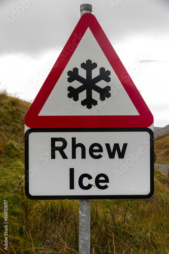 Snowflake ice triangular warning sign, bilingual Rhew, Wales, Un