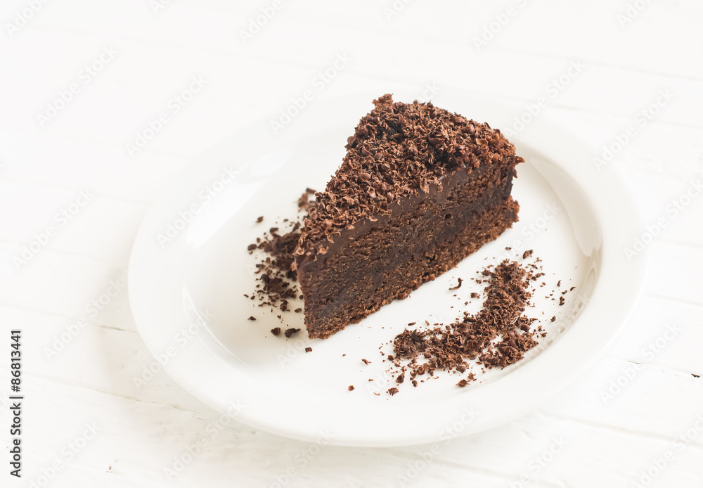 piece of chocolate cake on a white plate on a light background piece of chocolate cake on a white plate on a light background