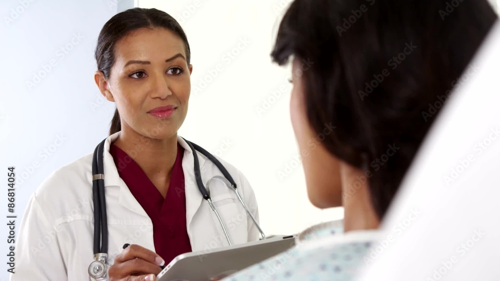 Over the shoulder shot of African American doctor using tablet computer Over the shoulder shot of African American doctor using tablet computer