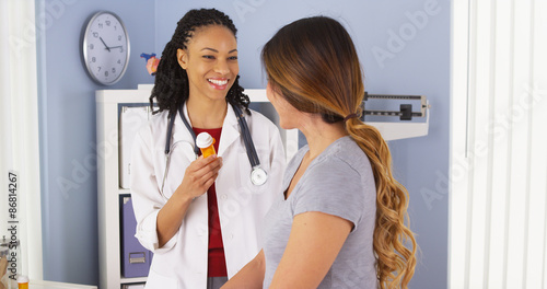 Black doctor explaining new prescription to Japanese patient