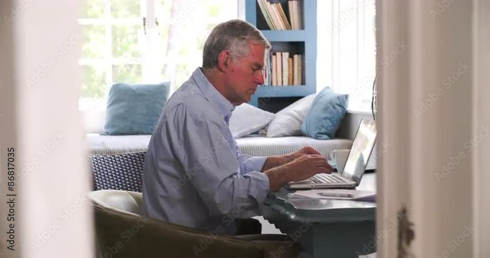 Senior Man At Desk Working In Home Office With Laptop Senior Man At Desk Working In Home Office With Laptop
