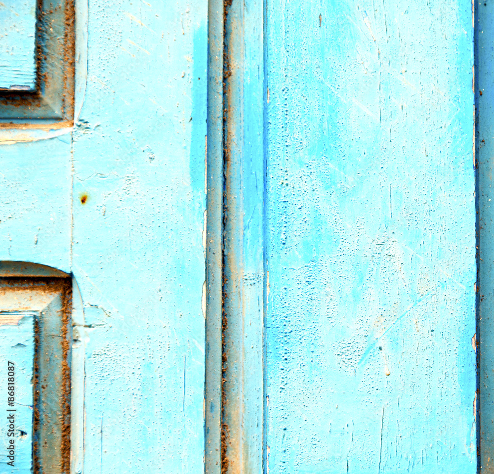 stripped paint in the blue wood door and rusty nail