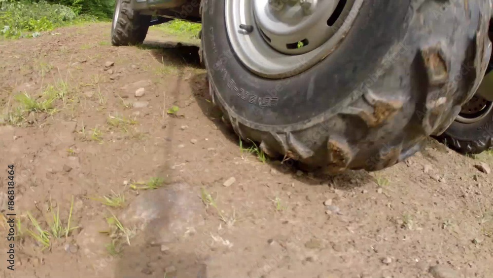 low shot of a side by side four wheeler traveling on a dirt road