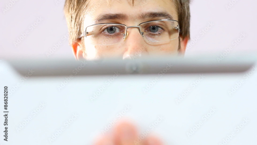 Sliding over man eyes while on tablet computer Sliding over man eyes while on tablet computer
