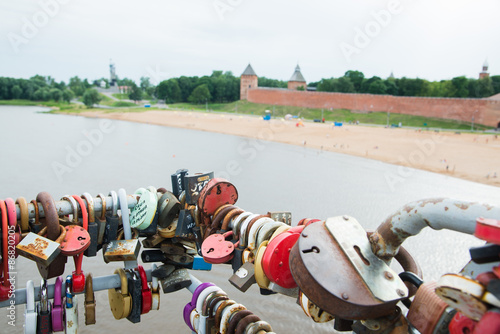 NOVGOROD, RUSSIA - JULY 8: Locks attached on railing of a pedestrian bridge over the river Volkhov. Russian city wedding tradition.