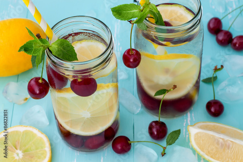 Detox fruit infused flavored water with cherry, lemon and mint. Refreshing summer homemade cocktail. Clean eating