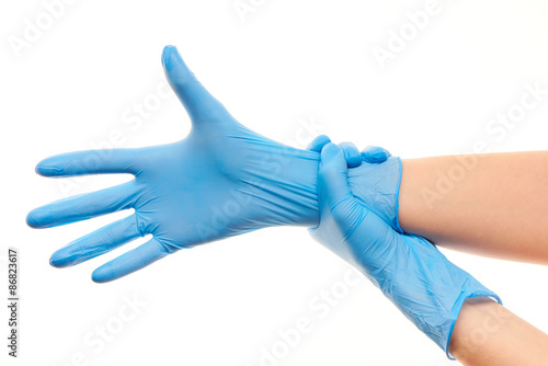Female doctor's hands putting on blue sterilized surgical gloves © IntelWond