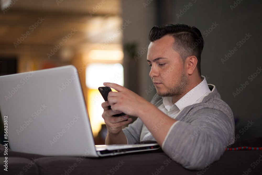 Man using smartphone and laptop Man using smartphone and laptop