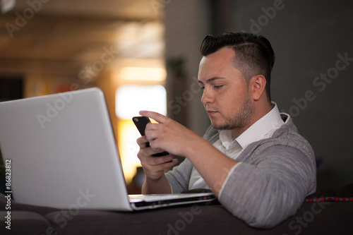 Man using smartphone and laptop