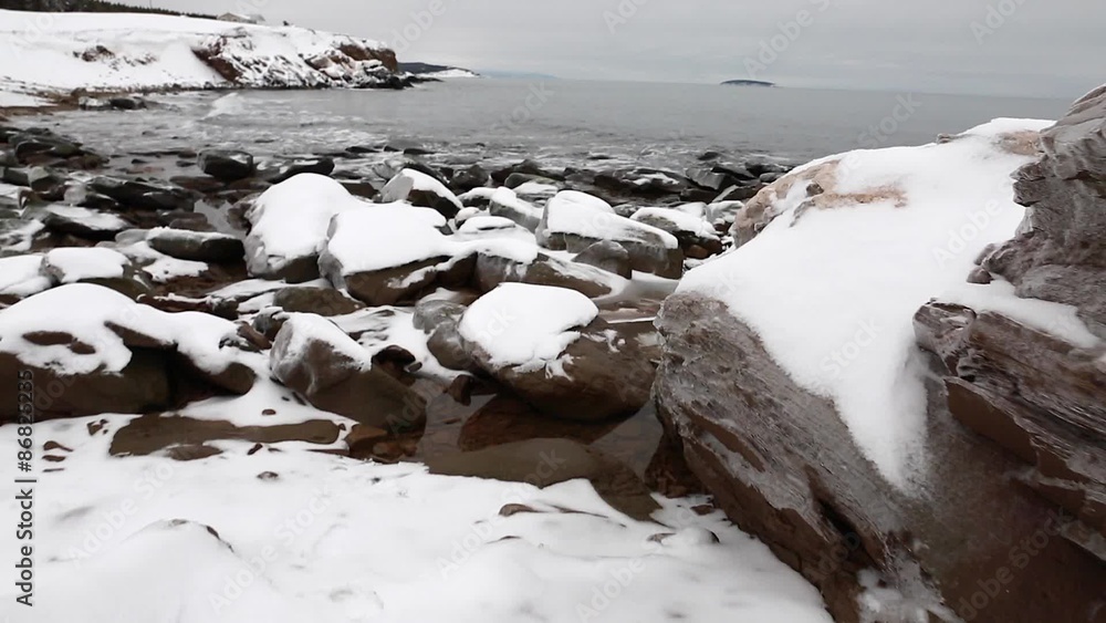 frozen snow covered rocks along coast frozen snow covered rocks along coast