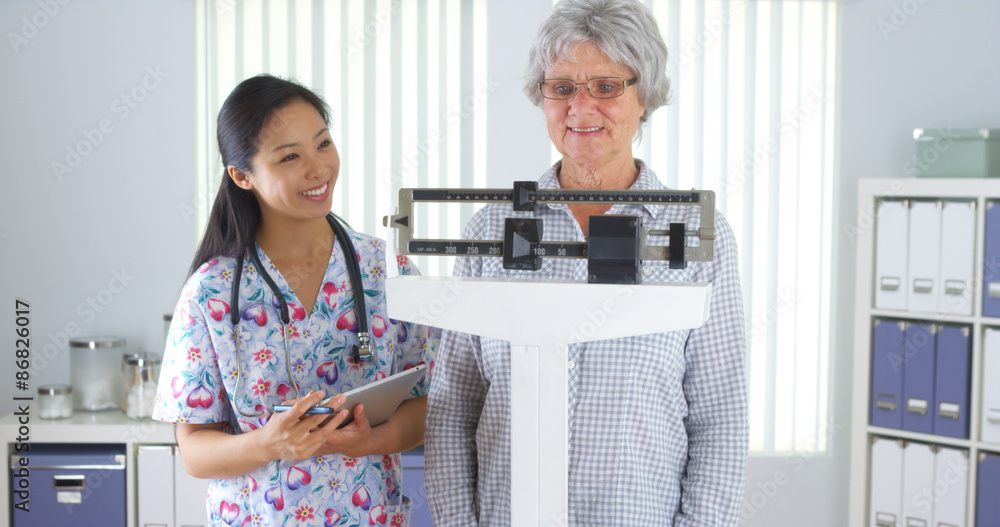 Chinese nurse weighing elderly patient Stock Photo Adobe Stock