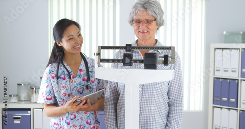 Φωτογραφία Chinese nurse weighing elderly patient
