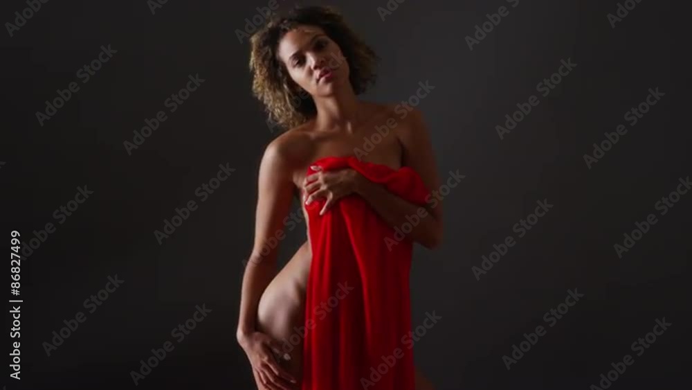 Nude African woman standing holding red cloth Nude African woman standing holding red cloth