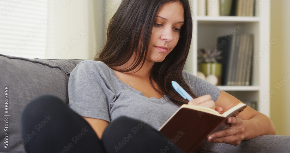 Hispanic woman writing in her diary Hispanic woman writing in her diary